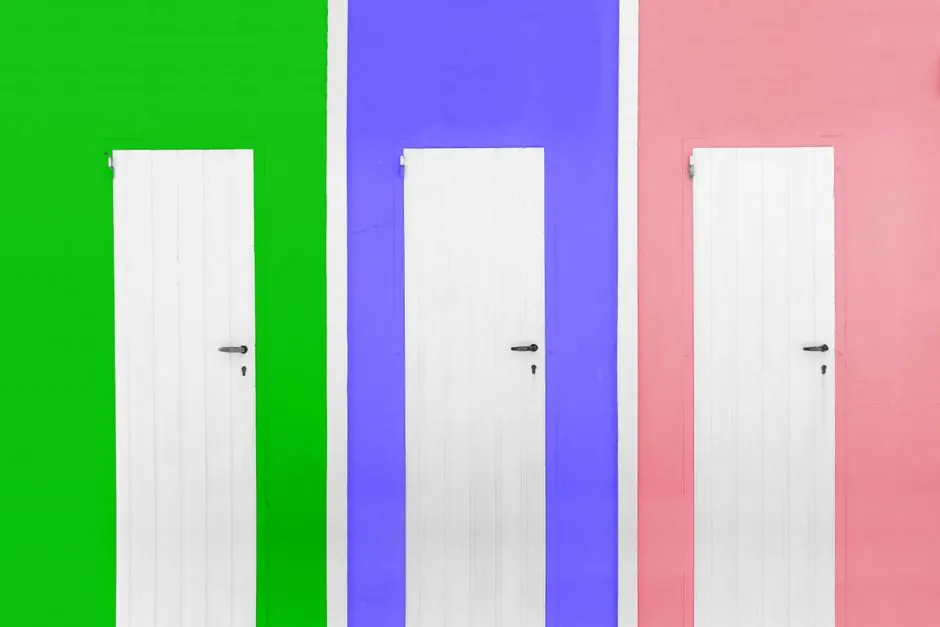 Three white doors against bright green, blue, and pink walls depicting modern style.